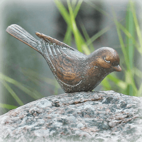 natuurlijke grafstenen bronzen vogeltje op zwerfkei