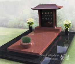 Chinees grafmonument met bloemen en plantenbak