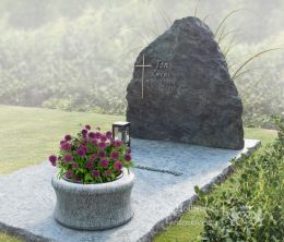 Grafmonument van ruw en groen natuursteen