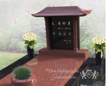 Chinees grafmonument met bloemen en plantenbak foto 2